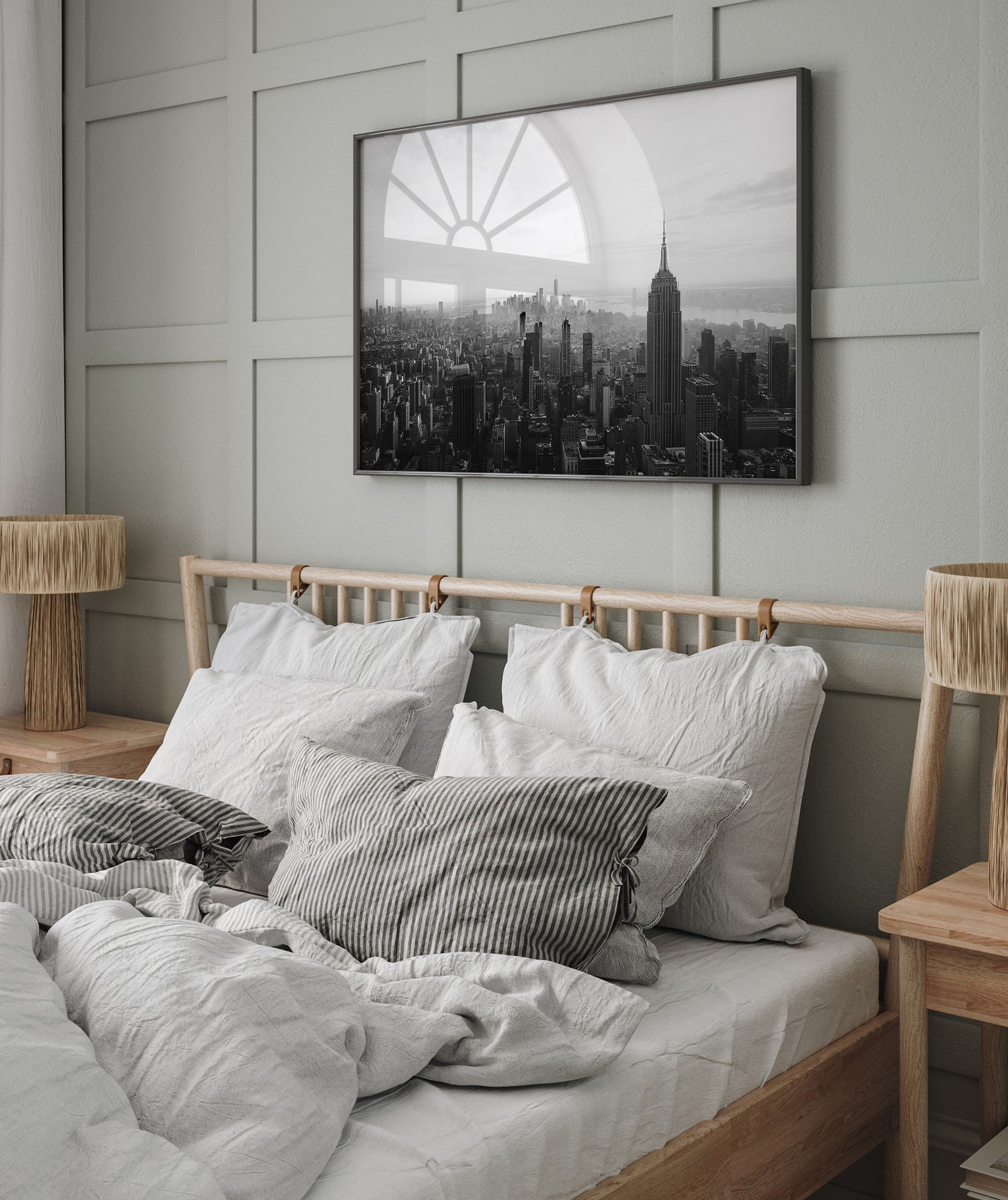 A cozy bedroom with a wooden bed, striped pillows, and the NYC Skyline Black and White photo above the headboard.