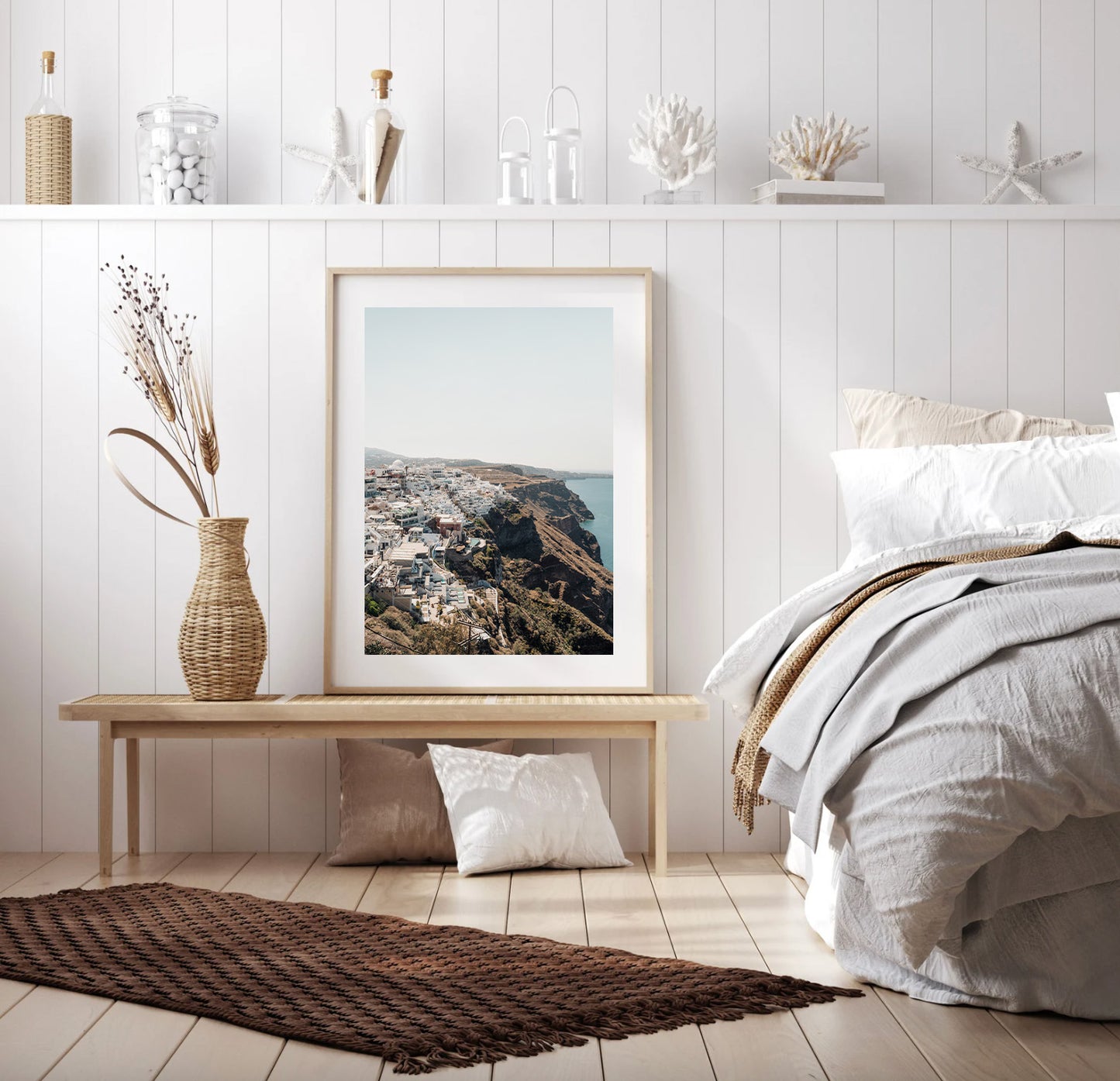 Cozy bedroom with neutral decor, a bench holding Perched framed art, dried flowers, and a neatly made bed.