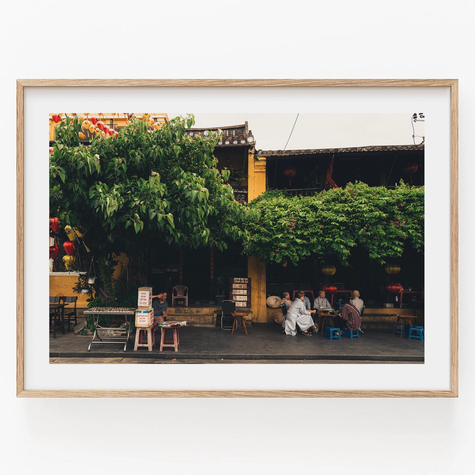 Framed photo Afternoon in Hoi An with a leafy tree, people sitting, and a yellow building in the background.