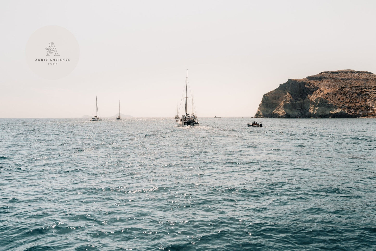 Afternoon Sail II depicts sailboats on a calm sea near a rocky coastline under a clear sky.