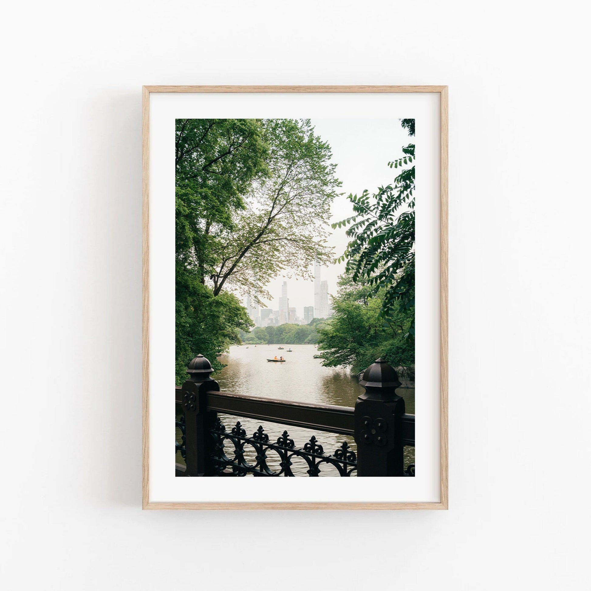 Beyond the Bridge: framed photo of a serene lake with trees, a distant skyline, and a small boat.