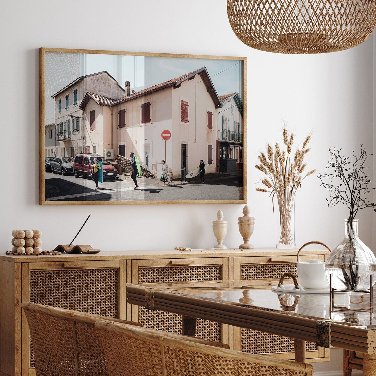 Dining room with wicker furniture, Biarritz Surfers artwork, and decorative vases on a wooden sideboard.