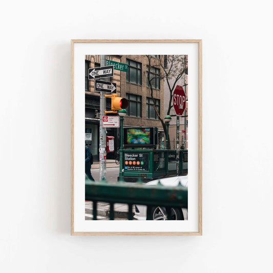 Framed photo titled Bleecker St. Station with traffic lights, street signs, and a subway entrance.