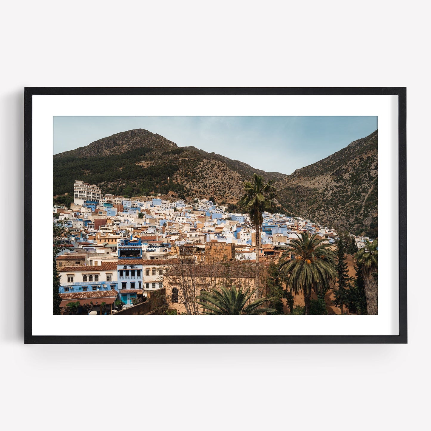 Framed Blue City Mountains photo of a hillside town with blue and white buildings amidst mountains.