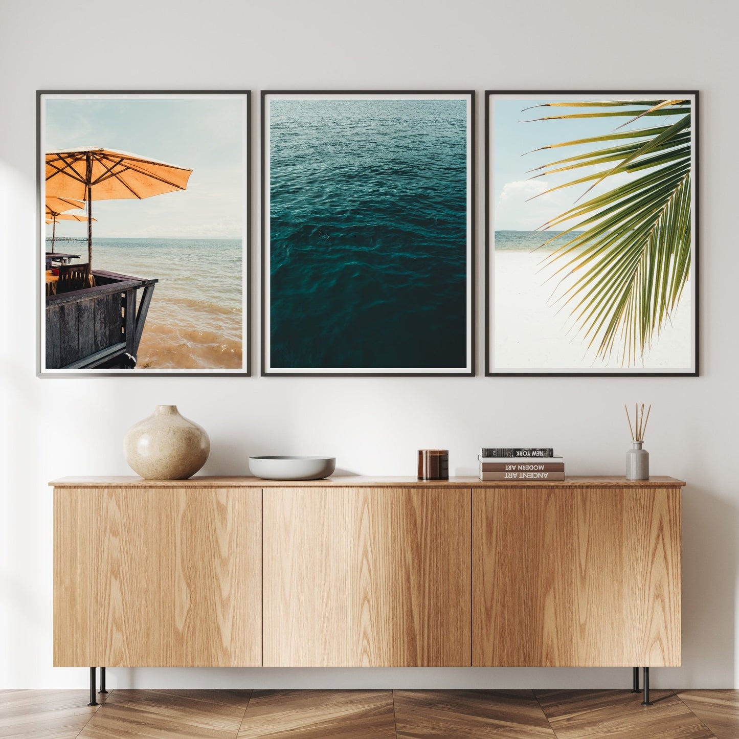 A minimalist living room with a wooden sideboard and Bright Shores - Set of 3 ocean-themed framed prints on the wall.