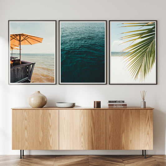 A minimalist living room with a wooden sideboard and Bright Shores - Set of 3 ocean-themed framed prints on the wall.