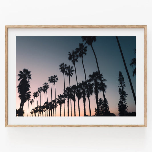 California Dreams: A framed photo of palm tree silhouettes against a sunset sky in a simple wooden frame.