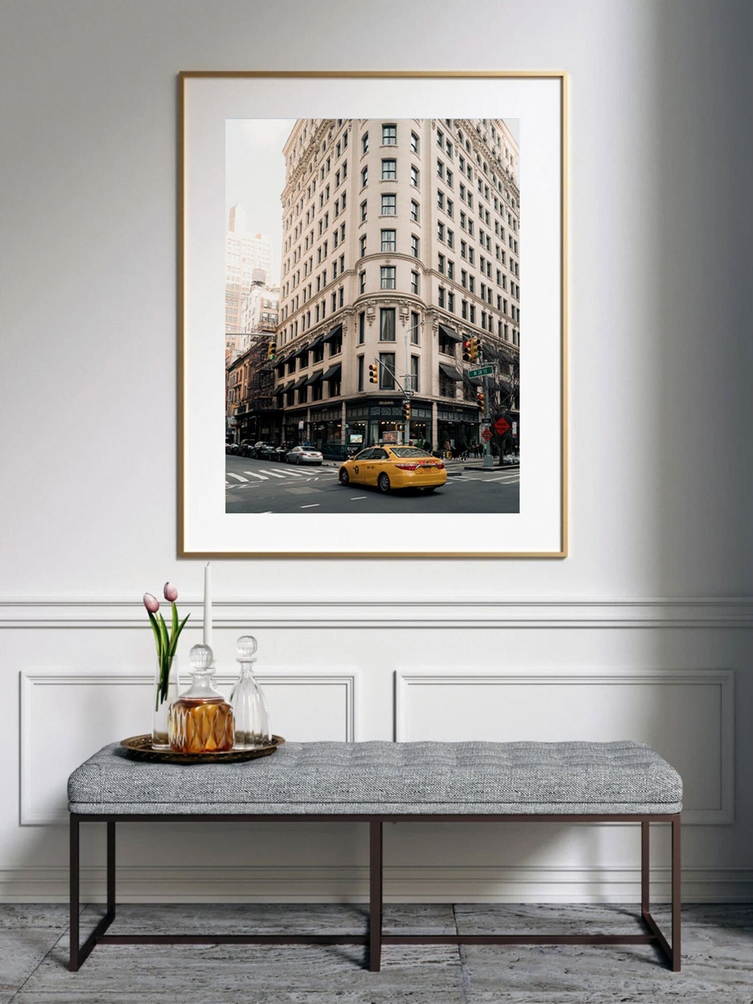 The Cecconis framed cityscape photo features a corner building with a yellow taxi above a bench with a tray and flowers.