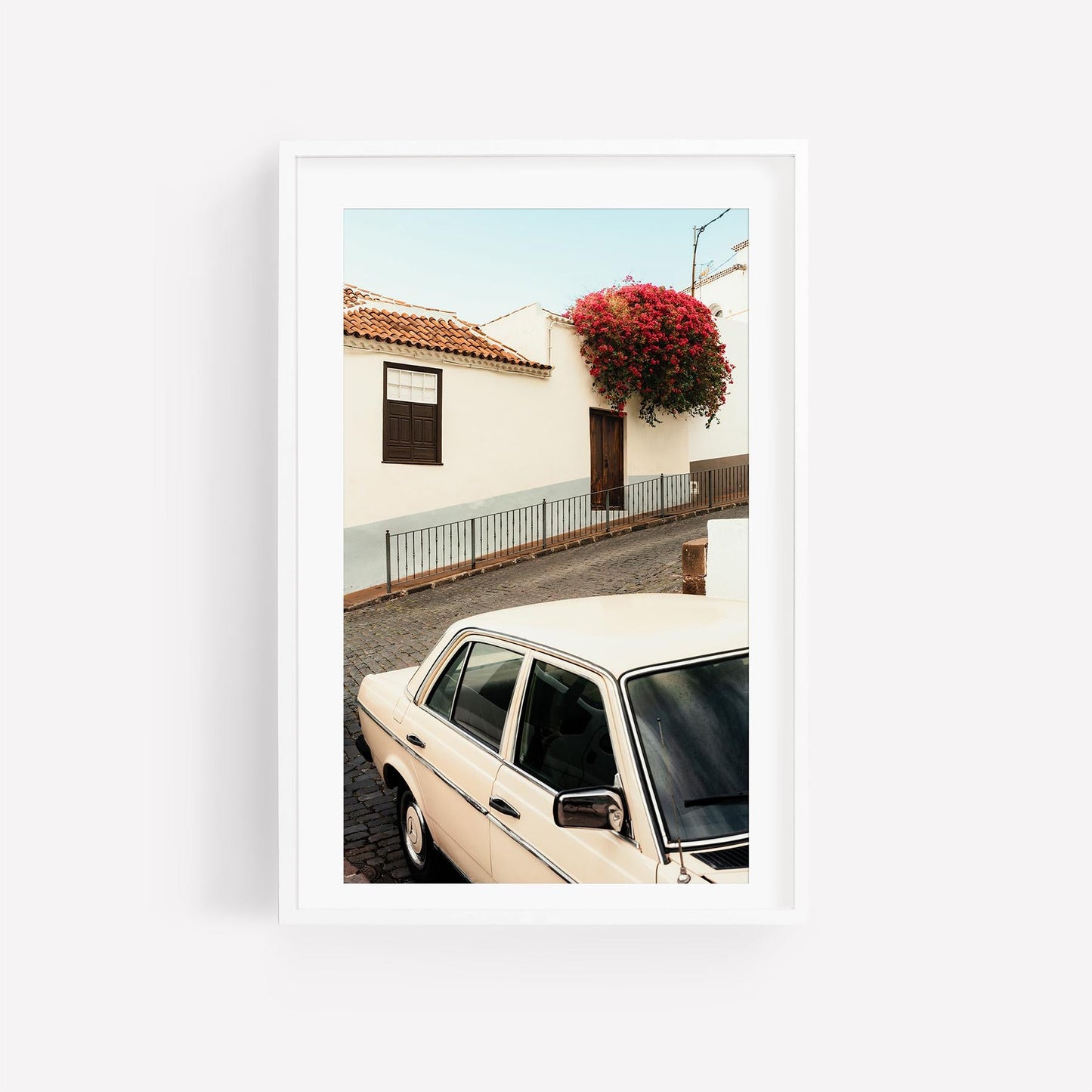 Classic in Bloom: Framed photo of a vintage white car by a white house with pink flowers overhead.