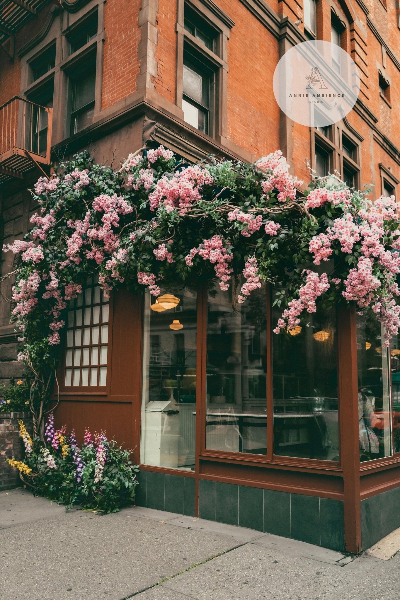 Corner café with large windows and cascading pink flowers against brick, part of Classic New York - Set of 3.