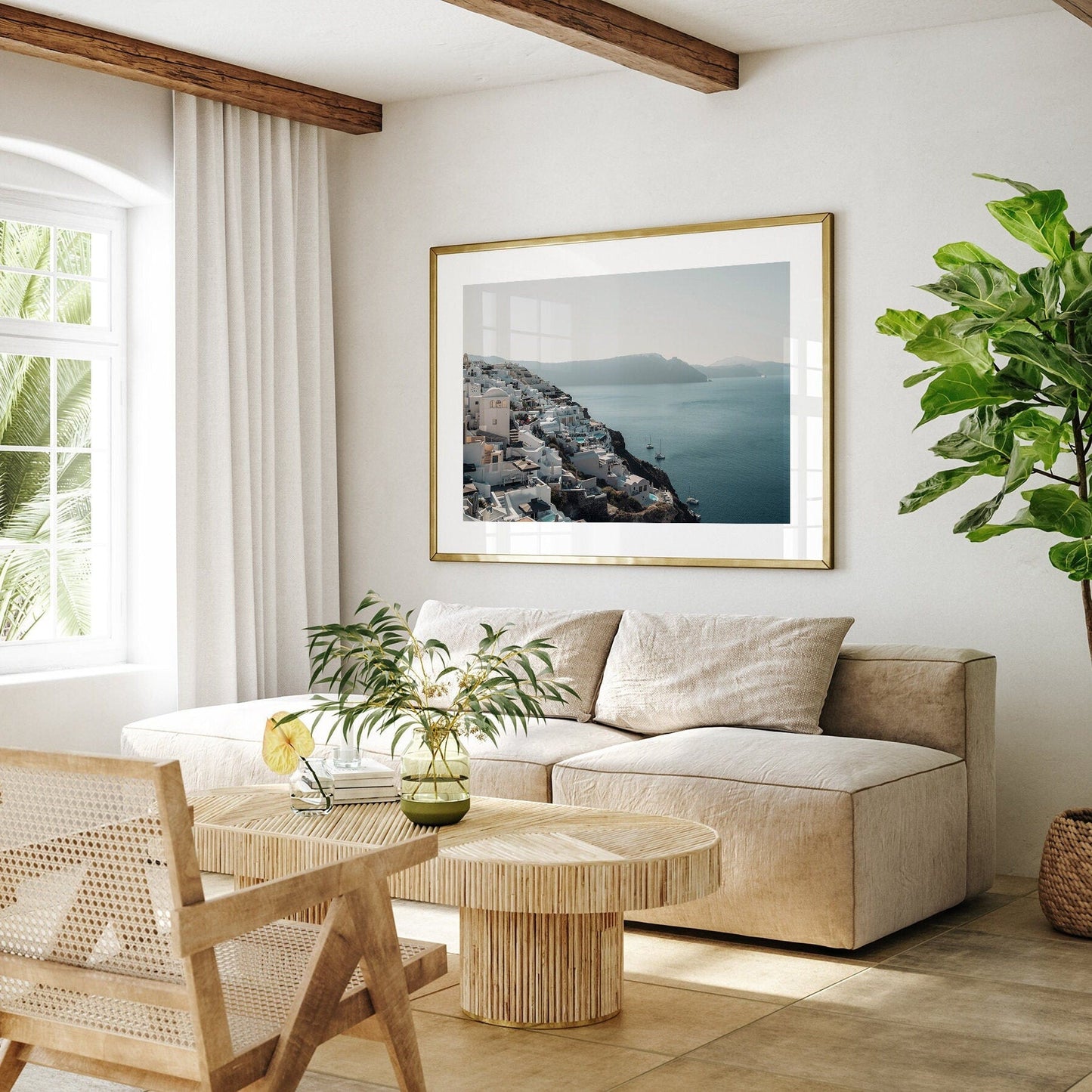 A bright living room with a beige sofa, wooden chair, and coffee table; potted plants and the Cliffside Village photo add decor.