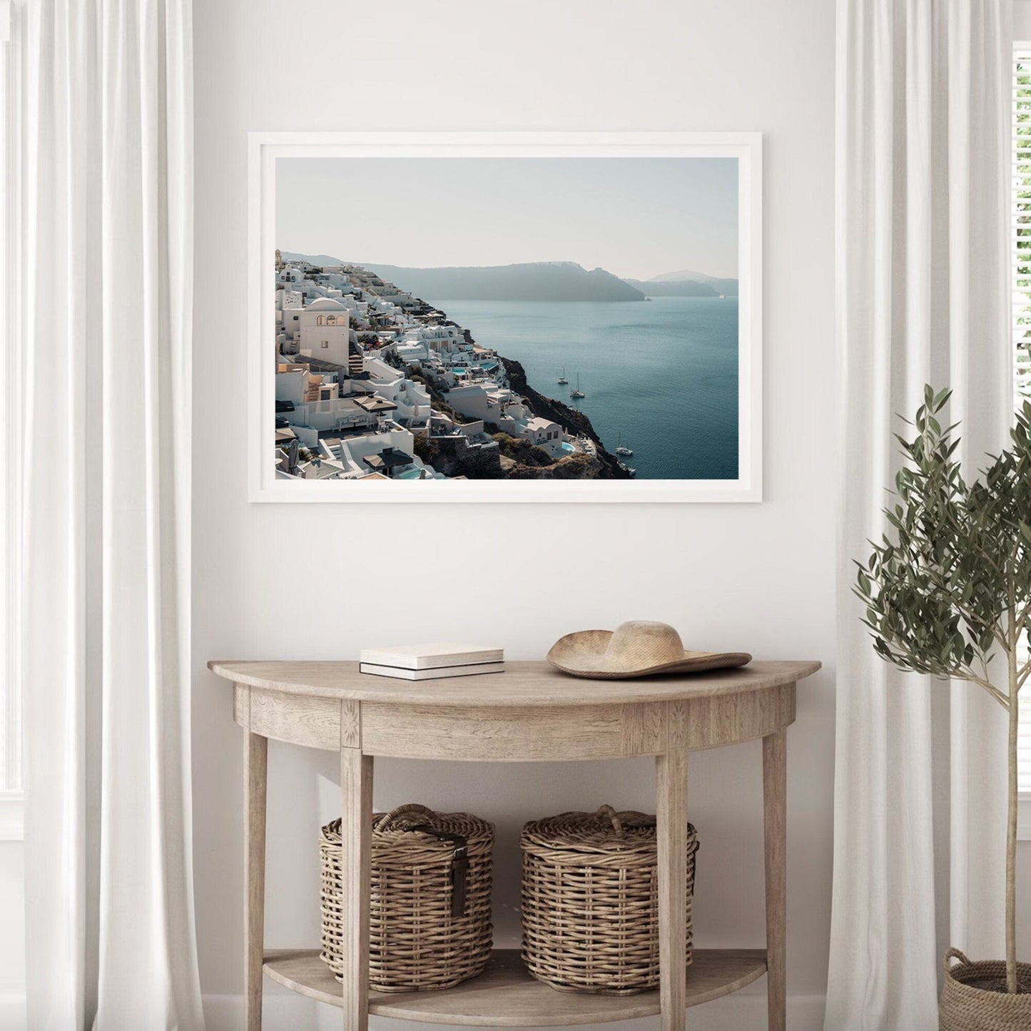 Cliffside Village photo above a wooden console with baskets, in a softly lit room with white curtains and a plant.