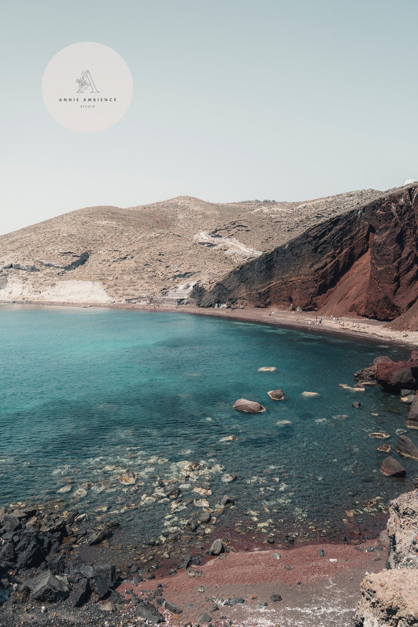 Colors of Santorini - Set of 3: Turquoise waters, red cliffs, and rocky shores beneath a pale blue sky.