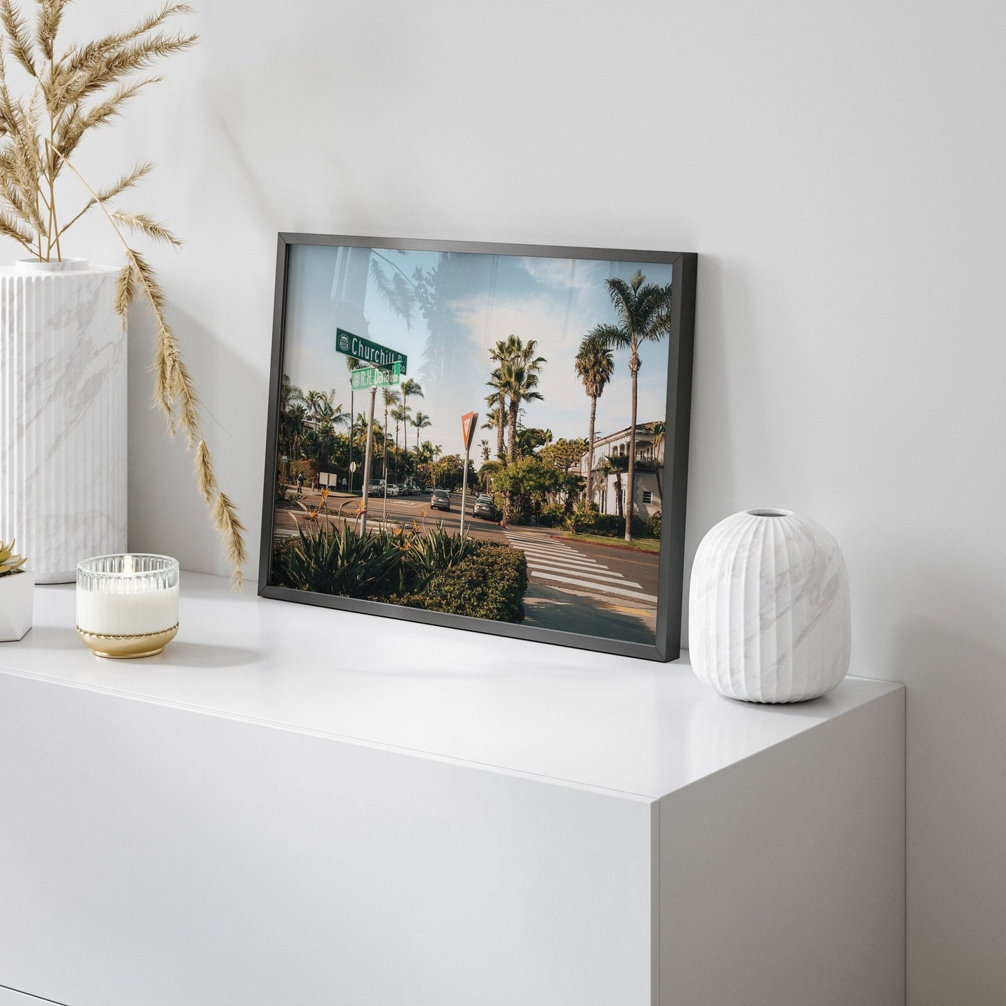 Coronado Crossing photograph displayed on a white tabletop with decorative vases and dried plants.