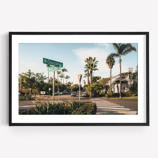 Coronado Crossing features a street view with palm trees, stop sign, and Churchill St sign under a clear blue sky.