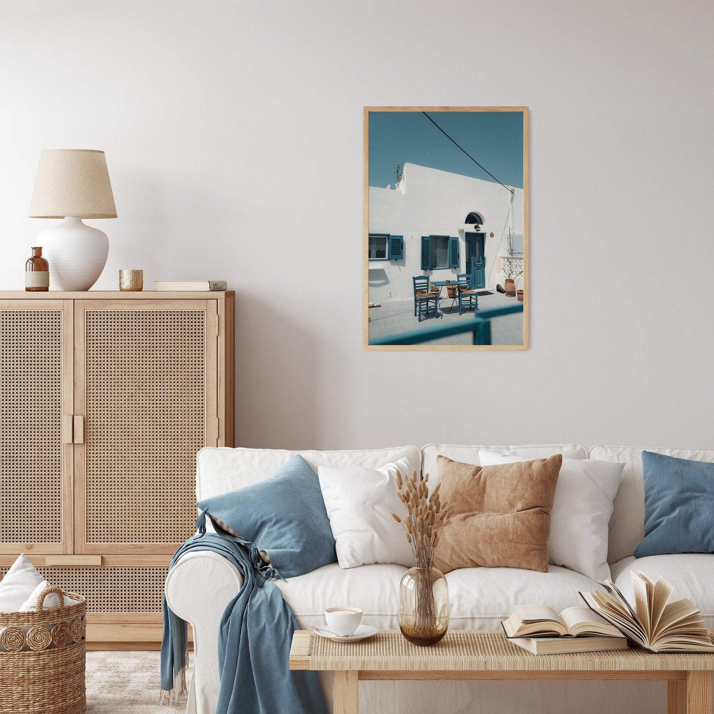 Cozy Haven with a white sofa, blue pillows, woven cabinet, and framed outdoor scene on the wall.