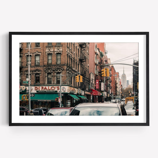 Framed Di Palos photo of a New York street with historic buildings and the Empire State Building.