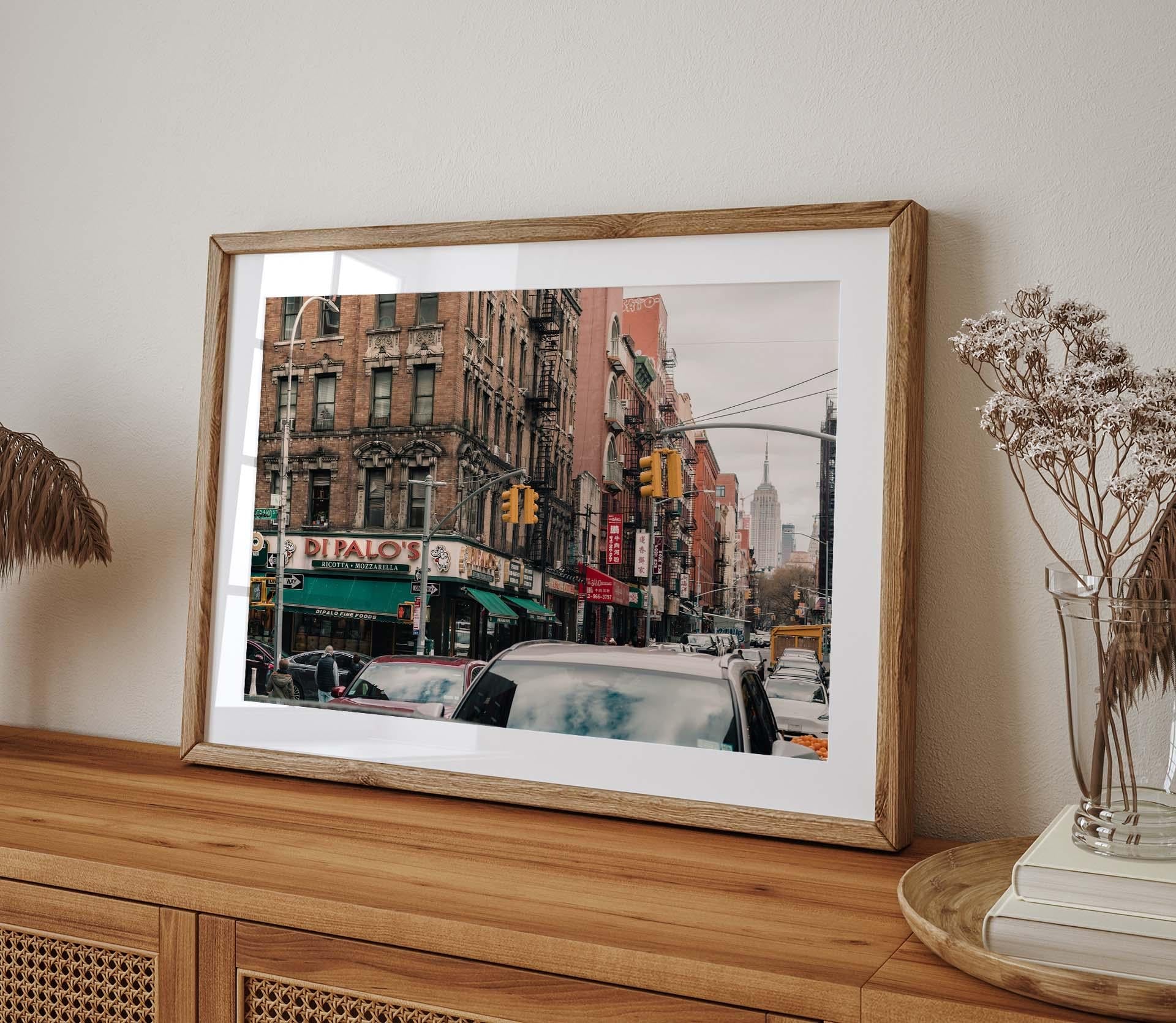 Di Palos photo of a bustling city street, displayed on a wooden shelf.