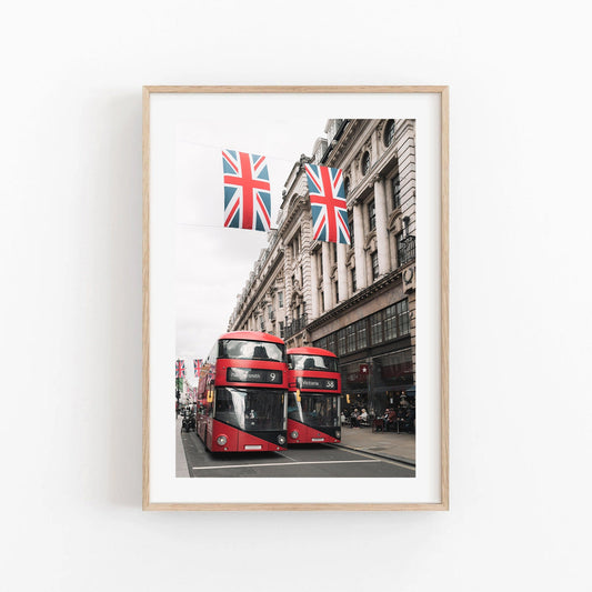 Framed photo of Double-deckers in London, with Union Jack flags above.