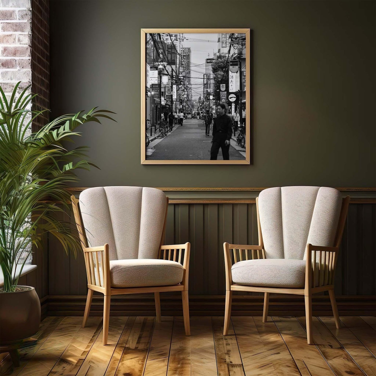 Two beige armchairs sit by a plant, with Echoes of Osaka Black and White framed on a dark green wall behind them.