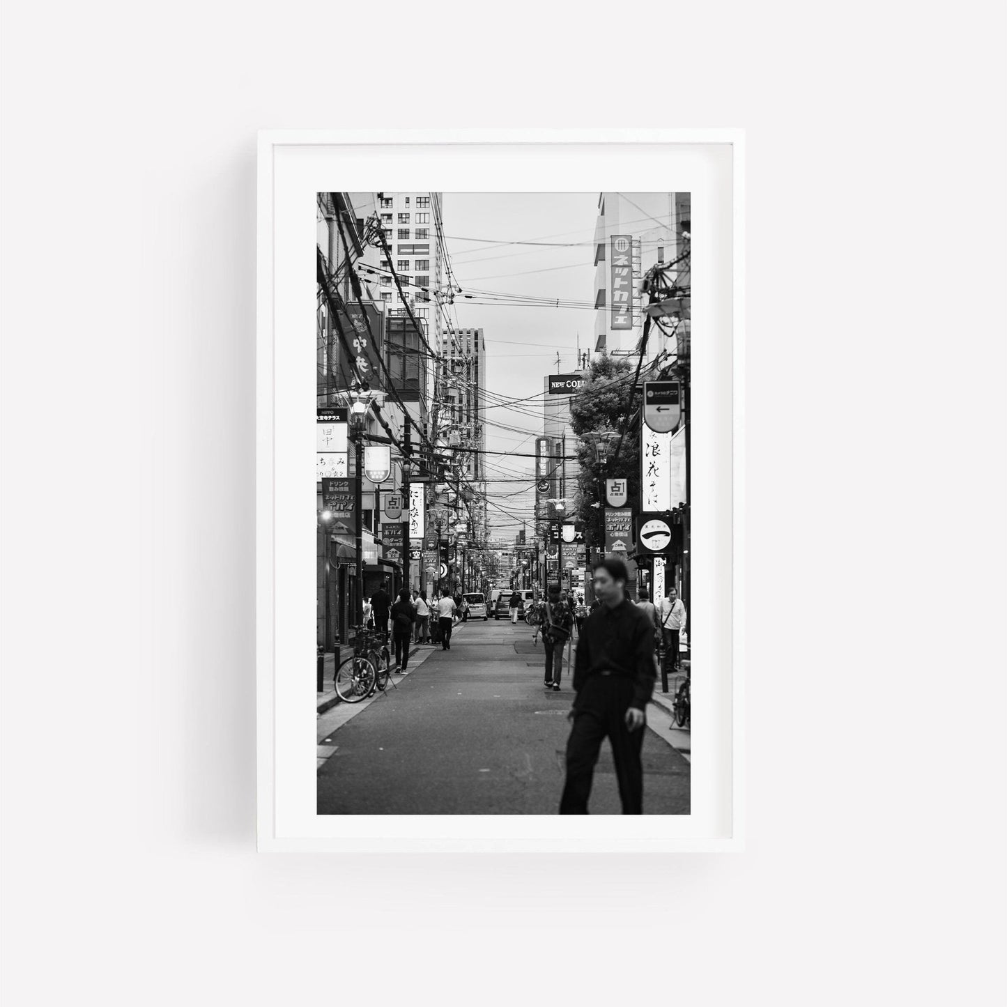 Echoes of Osaka Black and White: a bustling city street scene with people, bikes, and urban signs.