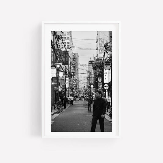 Echoes of Osaka Black and White: a bustling city street scene with people, bikes, and urban signs.