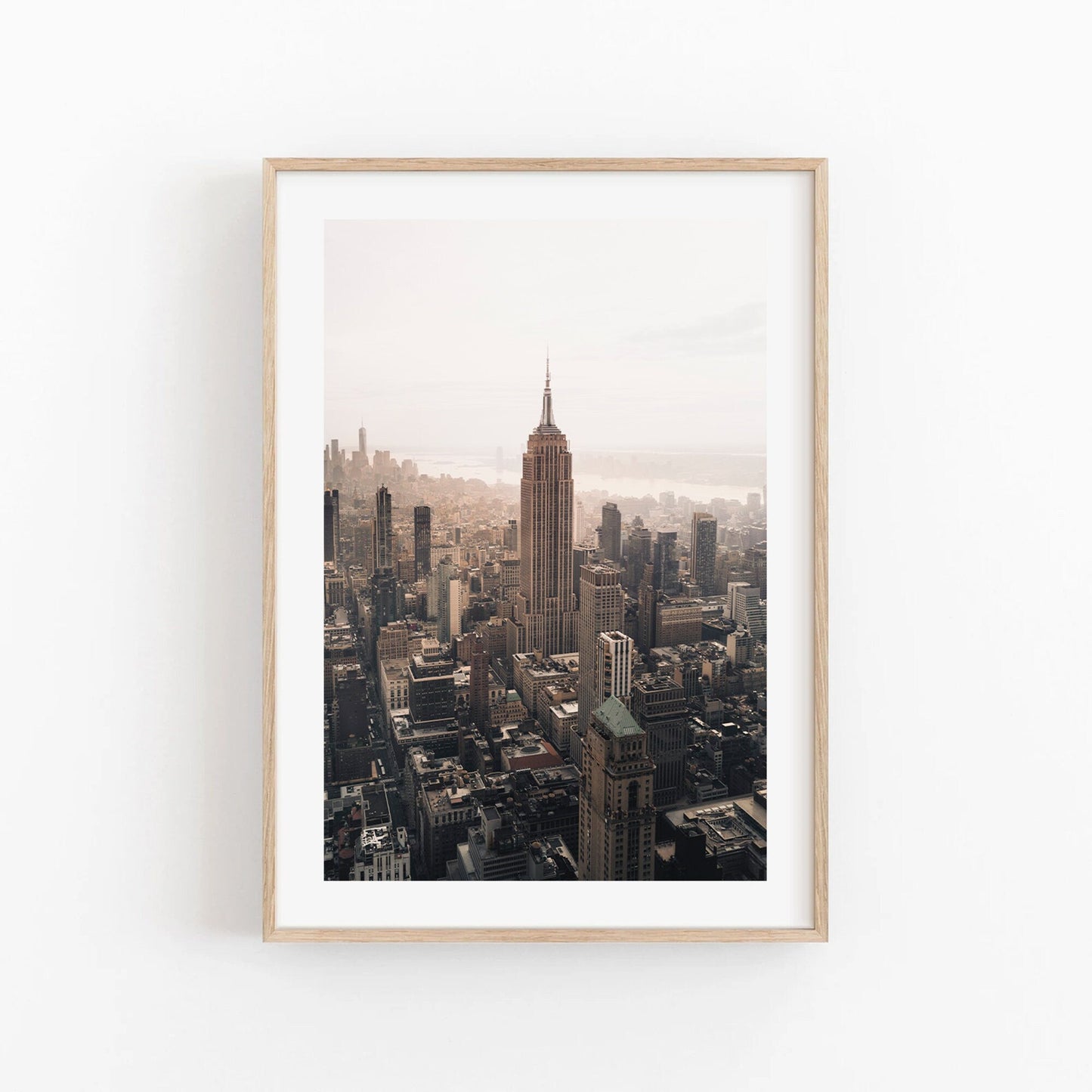 Framed photo of the Empire State Building against a cloudy sky.
