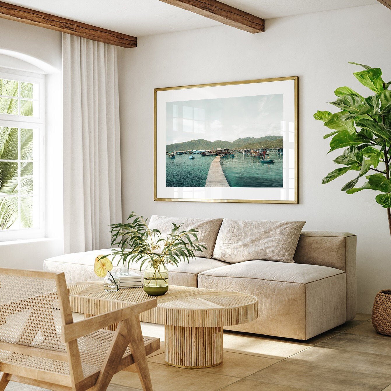 Cozy living room with beige furniture, a large plant, and Fishing Village I framed on the wall.