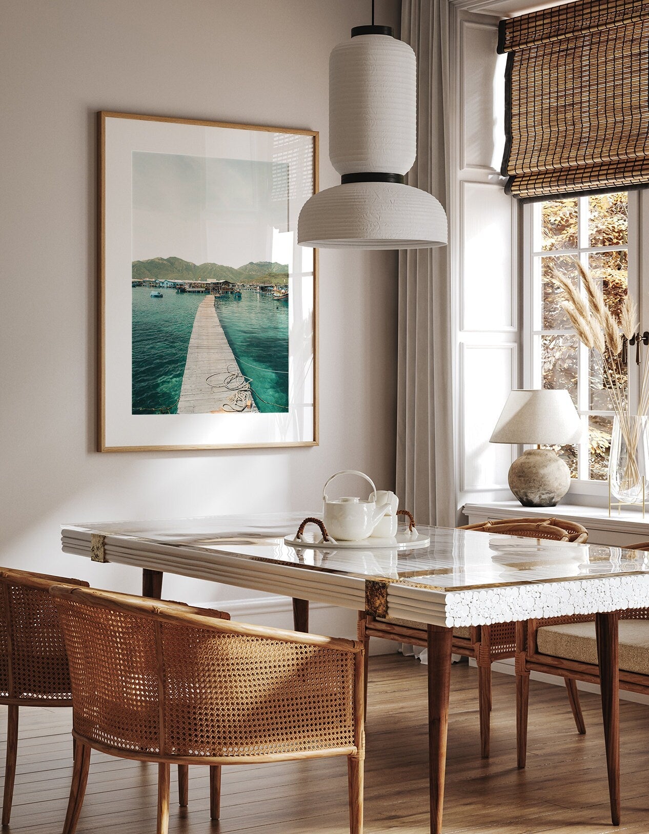 A cozy dining room with a wooden table, chairs, and Fishing Village II, a wall photo of a pier leading into the ocean.