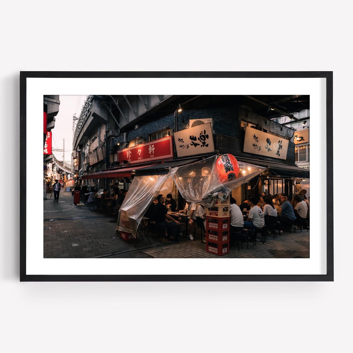 Street view of the vibrant Flavors Of Ueno, a lively Japanese izakaya with outdoor seating and glowing signs at night.