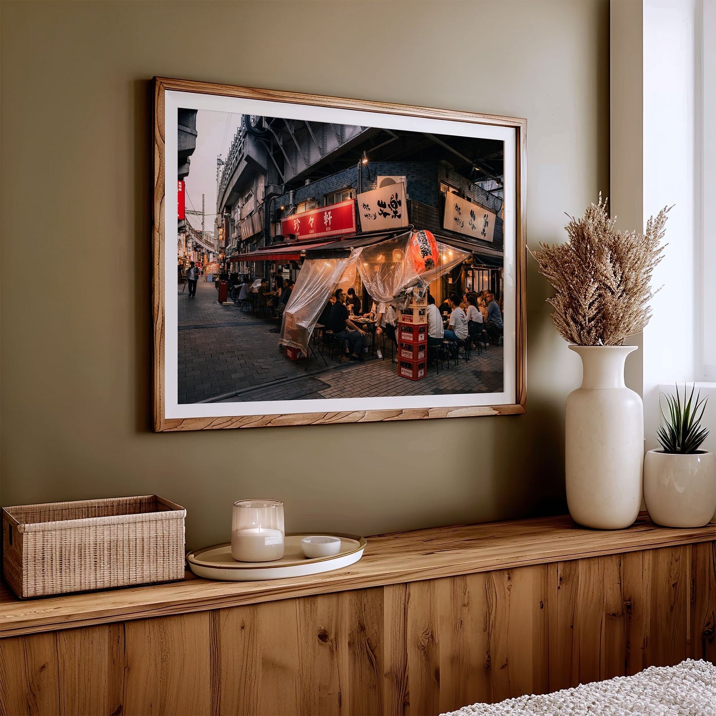 Flavors Of Ueno framed photo of a lively Japanese street scene hangs above a dresser with vases and candle.