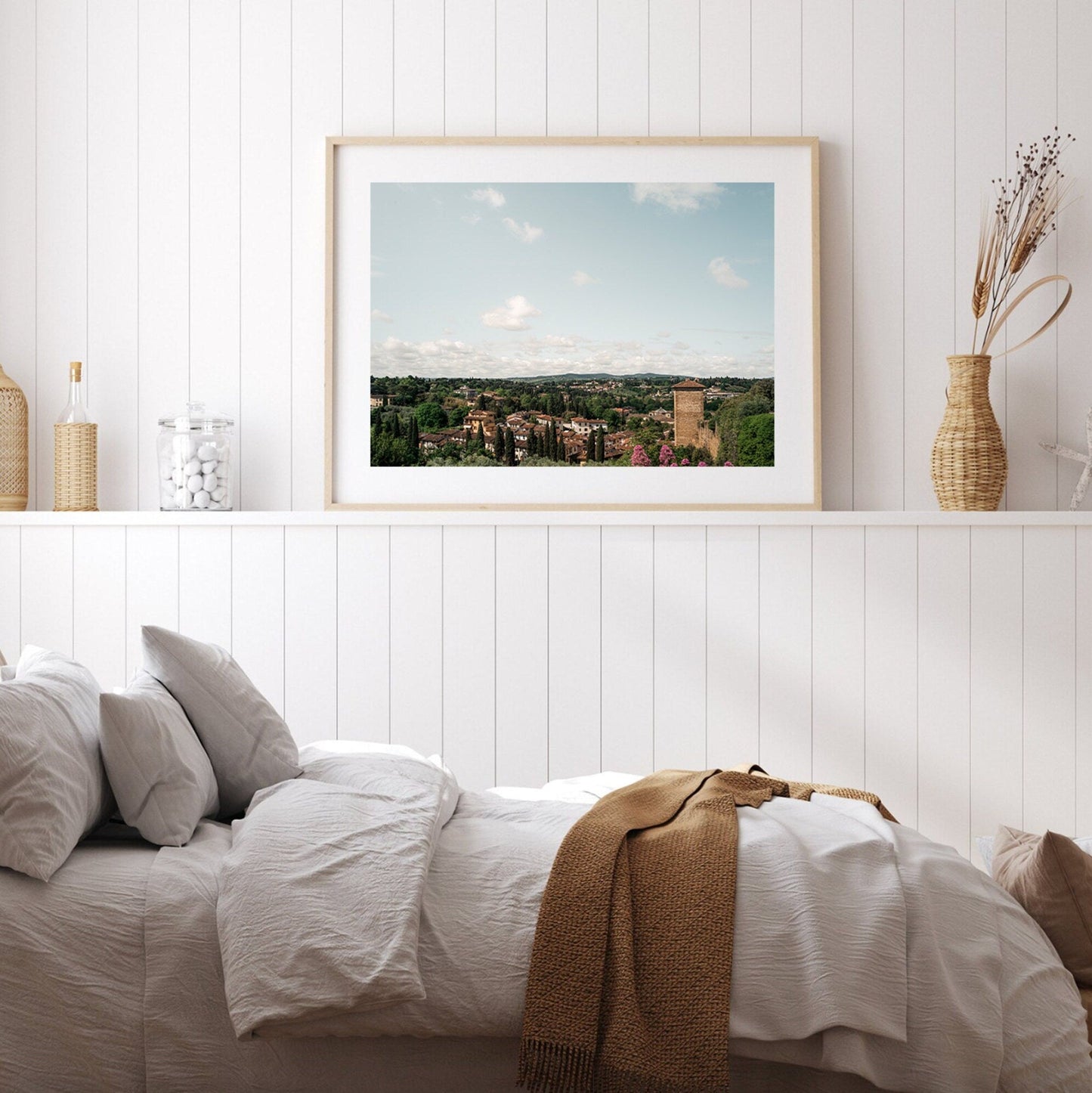 A cozy bedroom featuring the Florence Countryside photo, white bedding, and neutral decor accents.