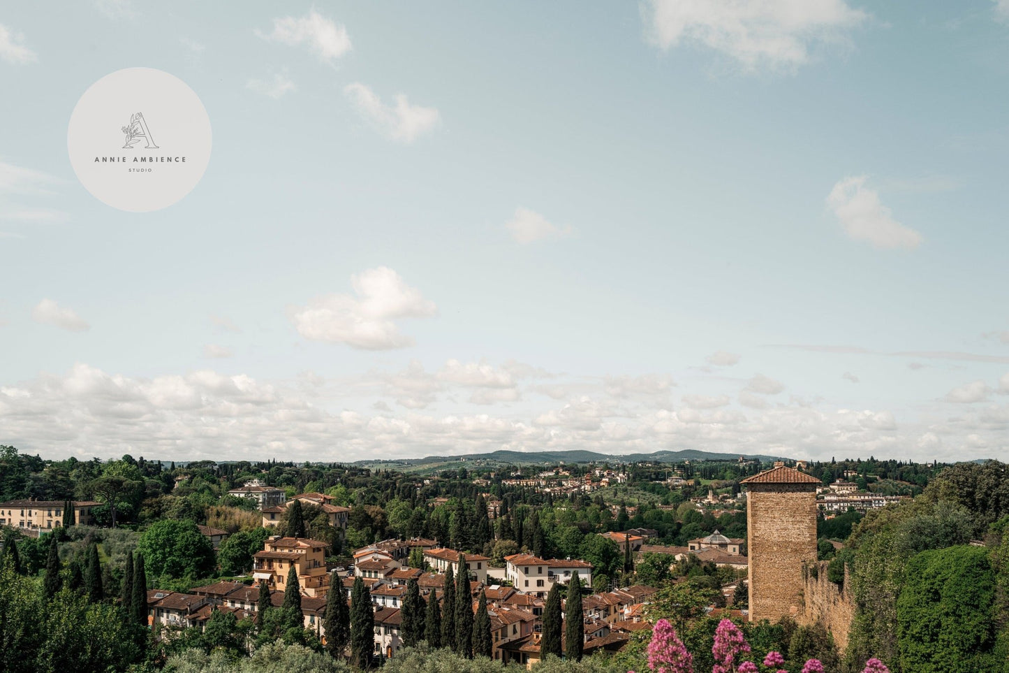 Florence Countryside: A scenic town view with red-roofed buildings, lush greenery, and hills beneath a cloudy sky.