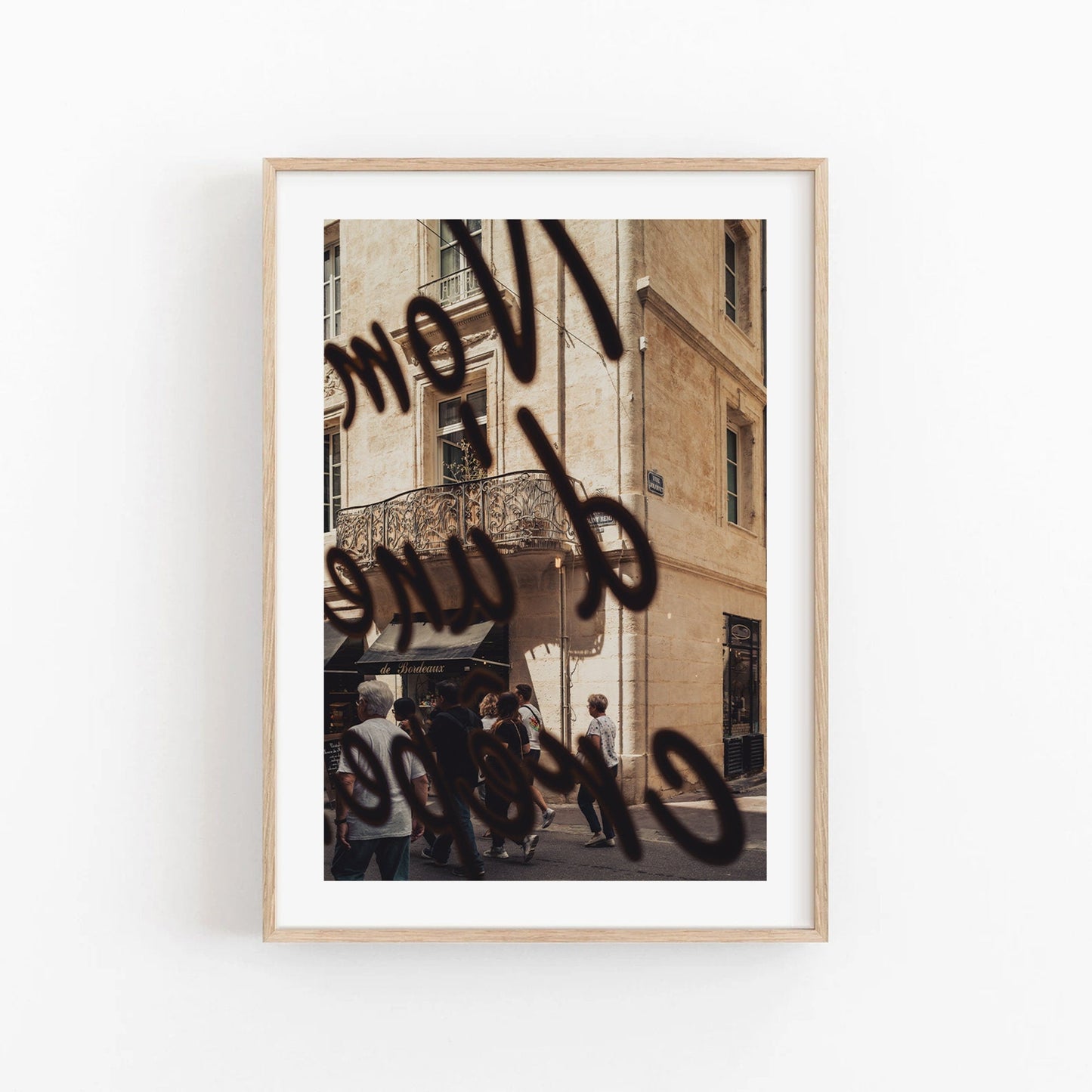 Framed photo of a street scene titled French Charm, featuring people and bold, cursive black lettering.