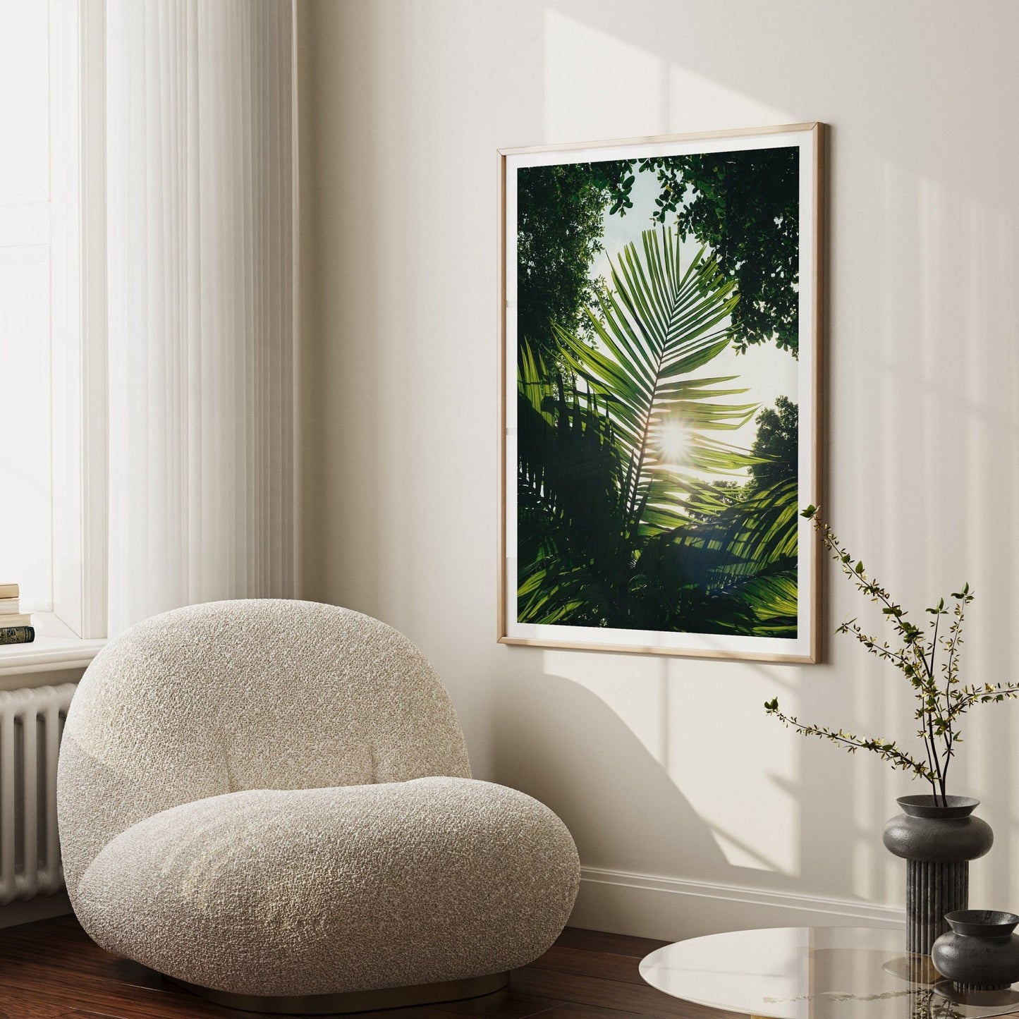A cozy room with a plush chair, Glimpse of Hope framed on the wall, and a small vase with twigs.