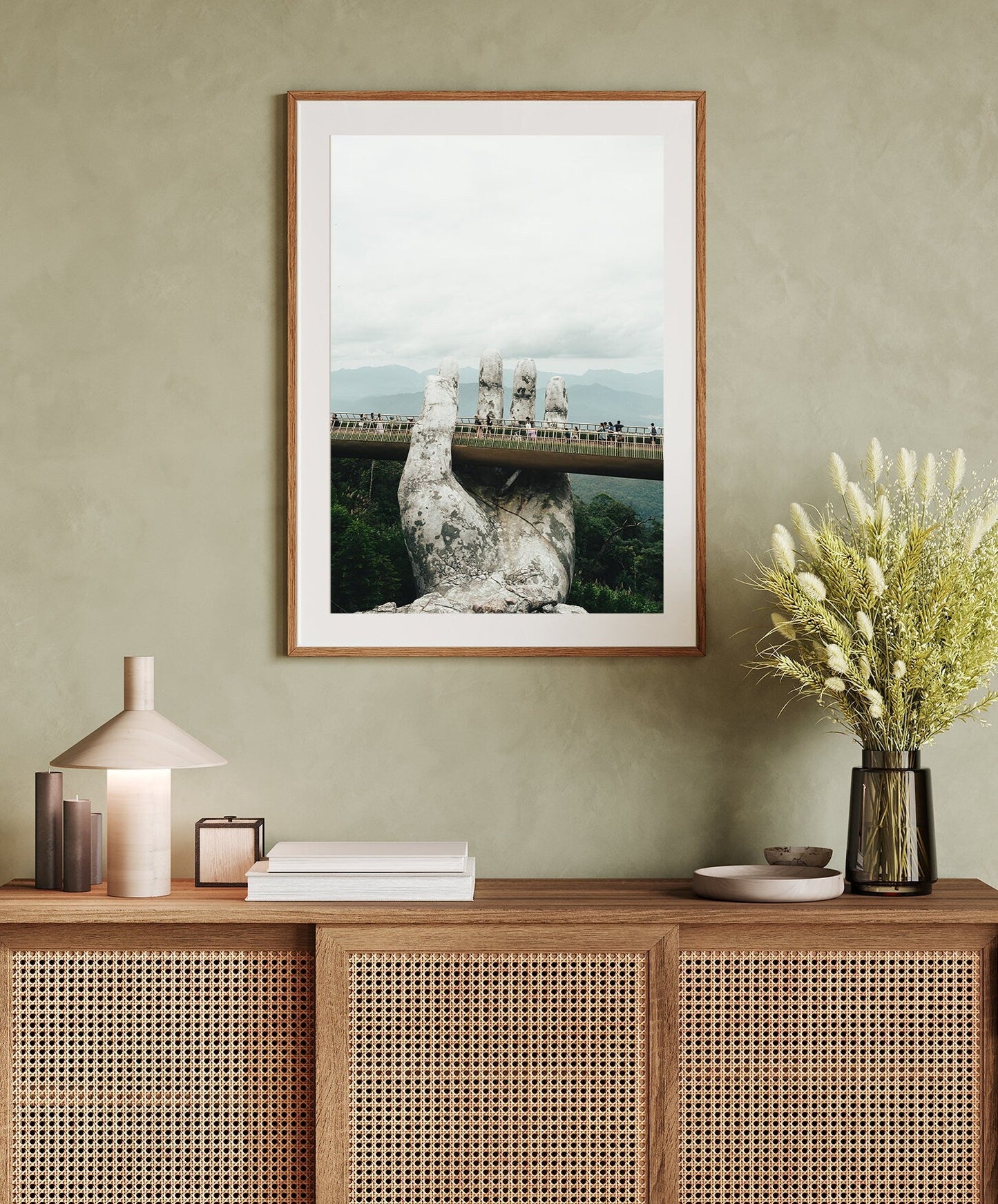 Framed Golden Hand Bridge I photo above a wicker cabinet adorned with decorative items.