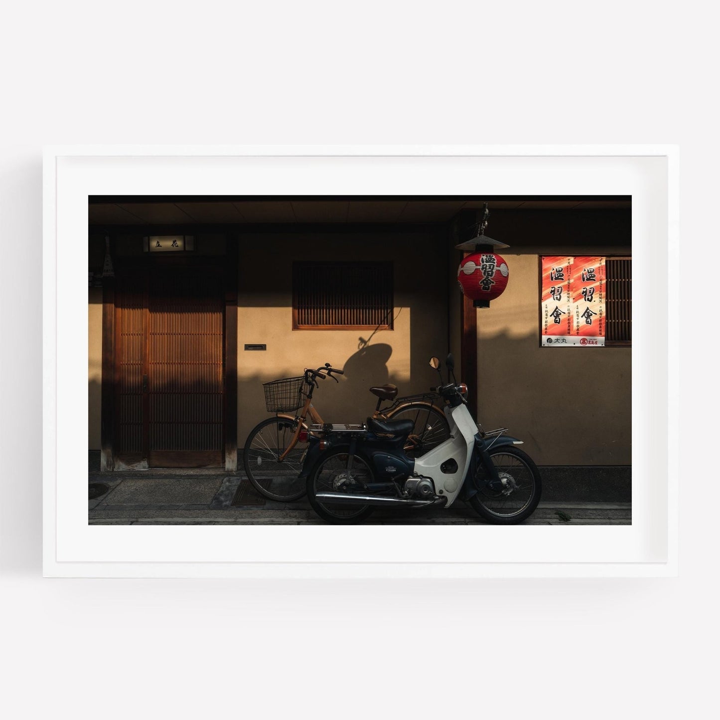Golden Shadow motorbike and bicycle parked outside a traditional Japanese building adorned with a red lantern and vintage posters.