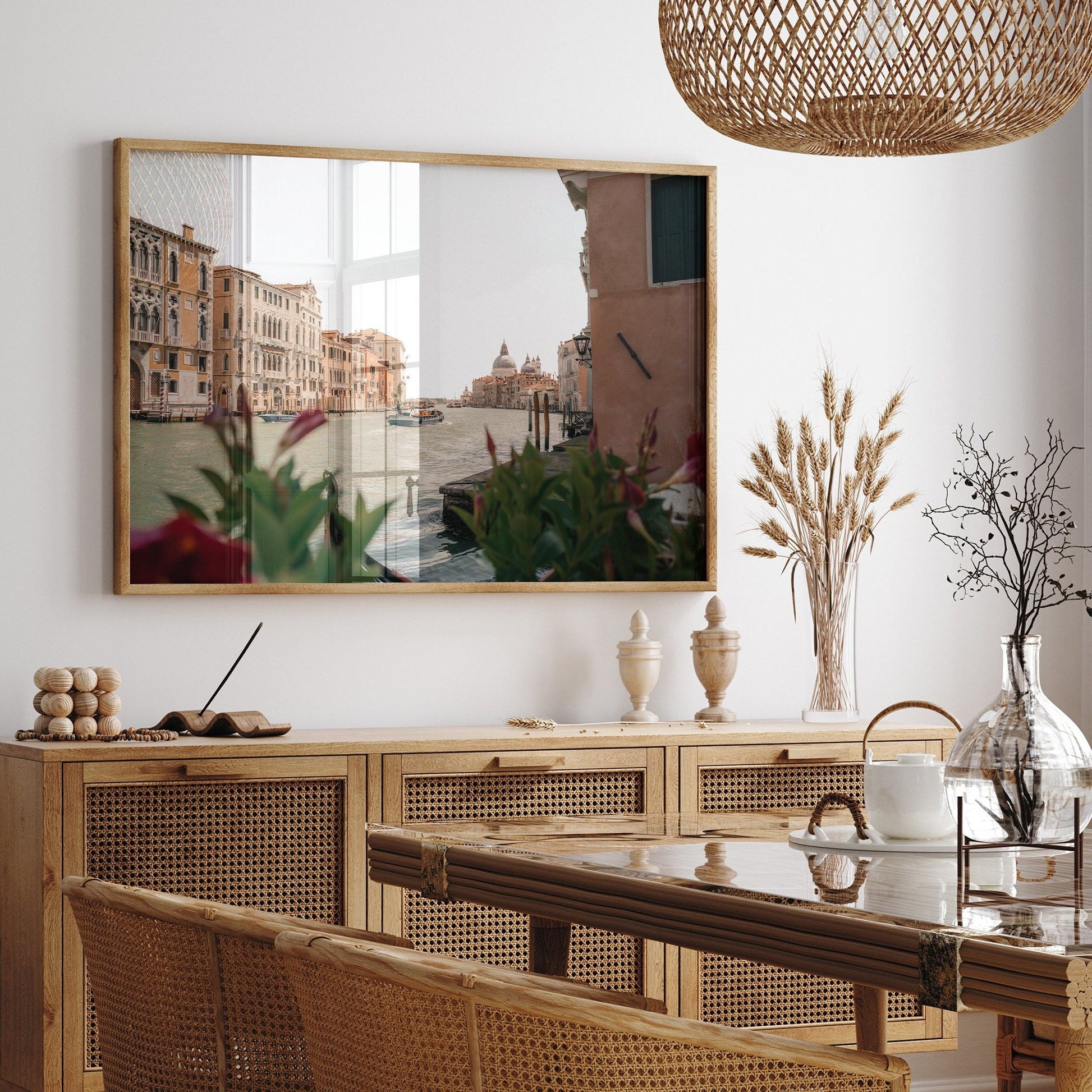 Dining room with wooden table, chairs, sideboard; Grand Canal photo on wall; wicker light fixture.