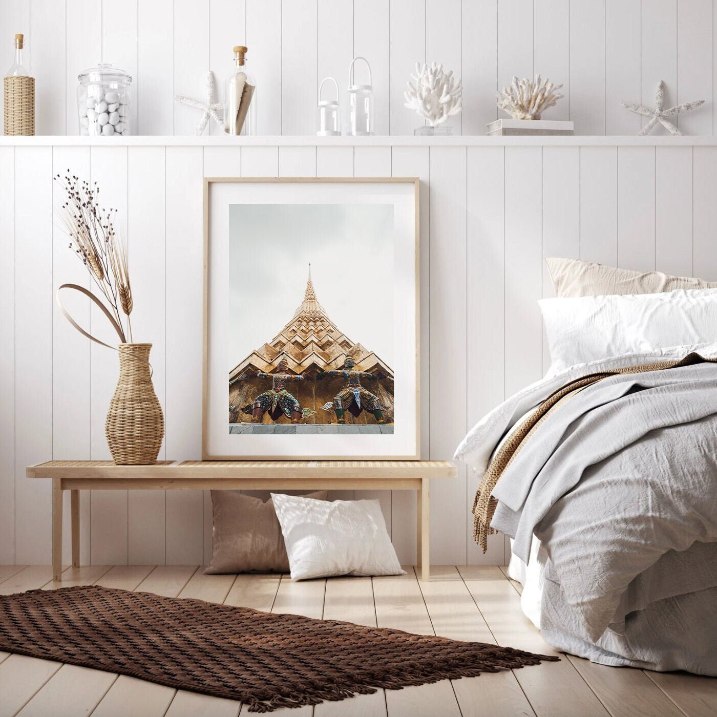 Cozy bedroom with wicker decor, a bench and framed art, neatly made bed against white paneled wall. Featuring Grand Palace I.