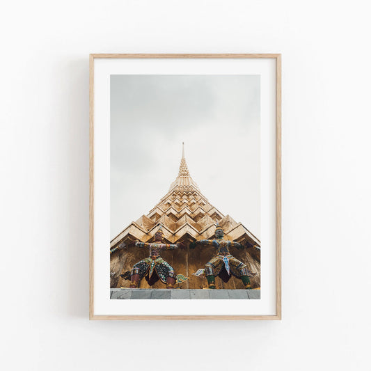 Framed photo of two statues beneath a golden temple spire with a light sky. Product: Grand Palace I.