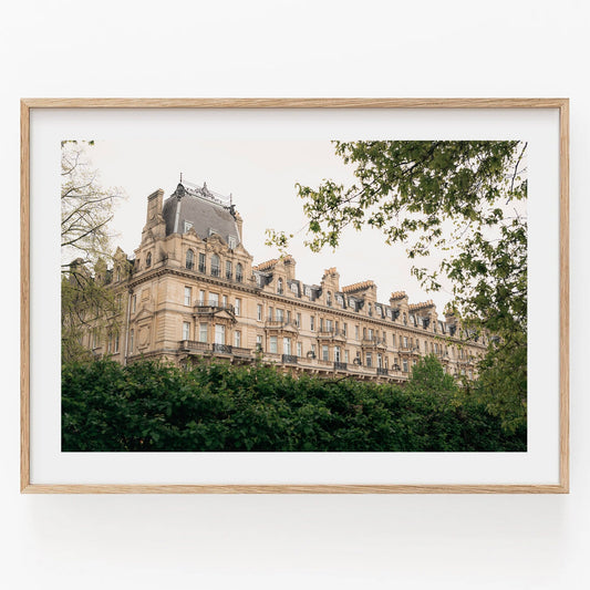 Grandeur: Framed photo of an ornate historic building with a leafy foreground and light sky.