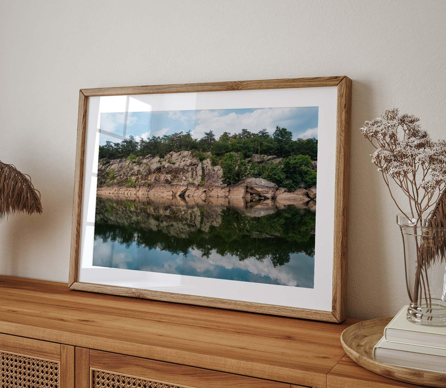 Framed Great Falls Park landscape photo on a wooden cabinet, showing a rocky cliff with forest reflection in a lake.