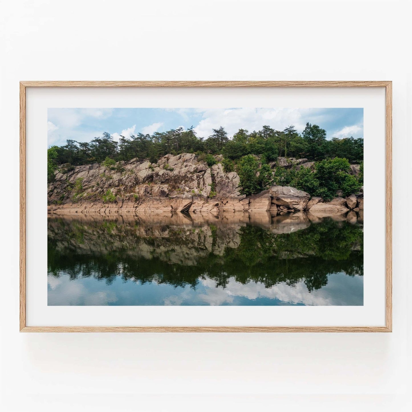 Framed Great Falls Park photo of rocky cliffs and trees reflecting in calm water, on a white background.