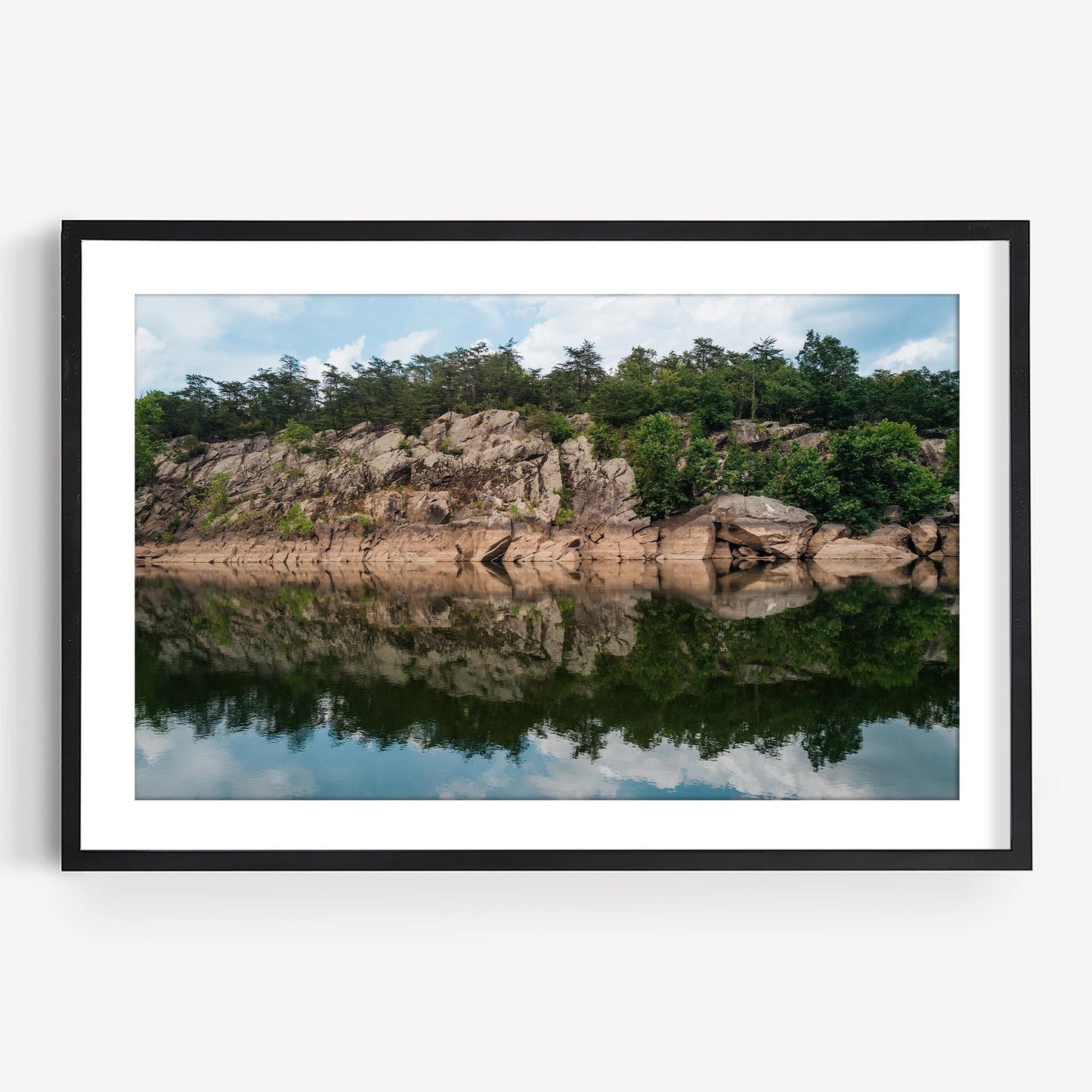 Framed Great Falls Park photo: rocky cliff, trees, calm river reflection under a blue sky with clouds.