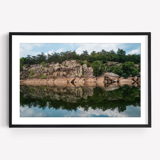 Framed Great Falls Park photo: rocky cliff, trees, calm river reflection under a blue sky with clouds.