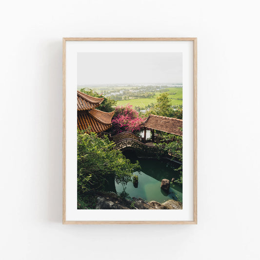 Framed photo titled Hang Pagoda featuring a serene garden with pavilion, bridge, and lush greenery over a pond.