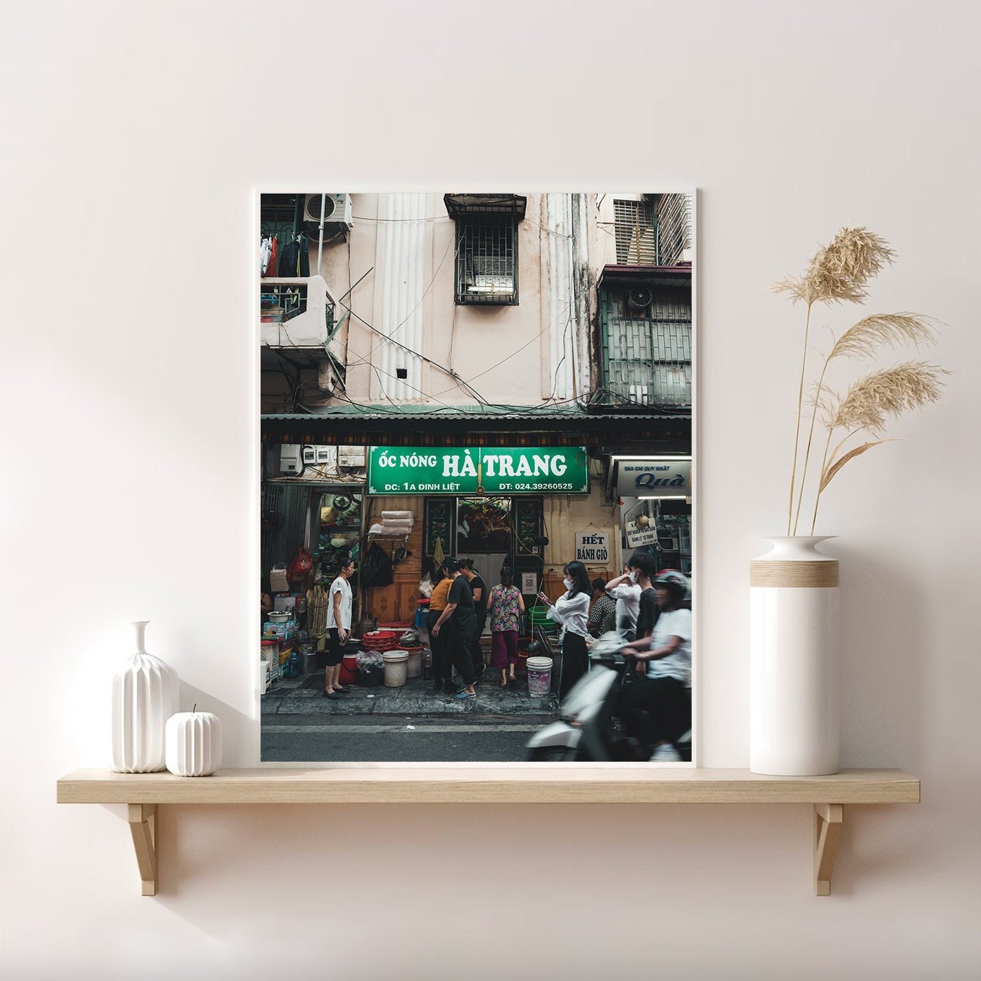 Framed Bustling Hanoi photo on a wooden shelf with minimal decor.