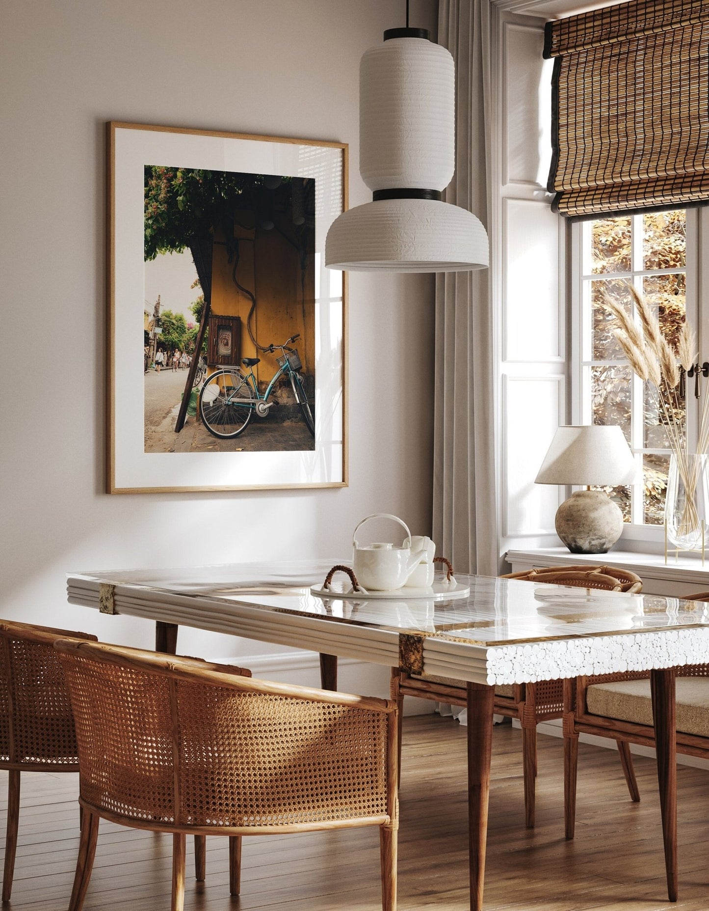 Stylish dining room featuring the Hoi An Bike photo, wicker chairs, a white table, and a teapot under pendant lighting.