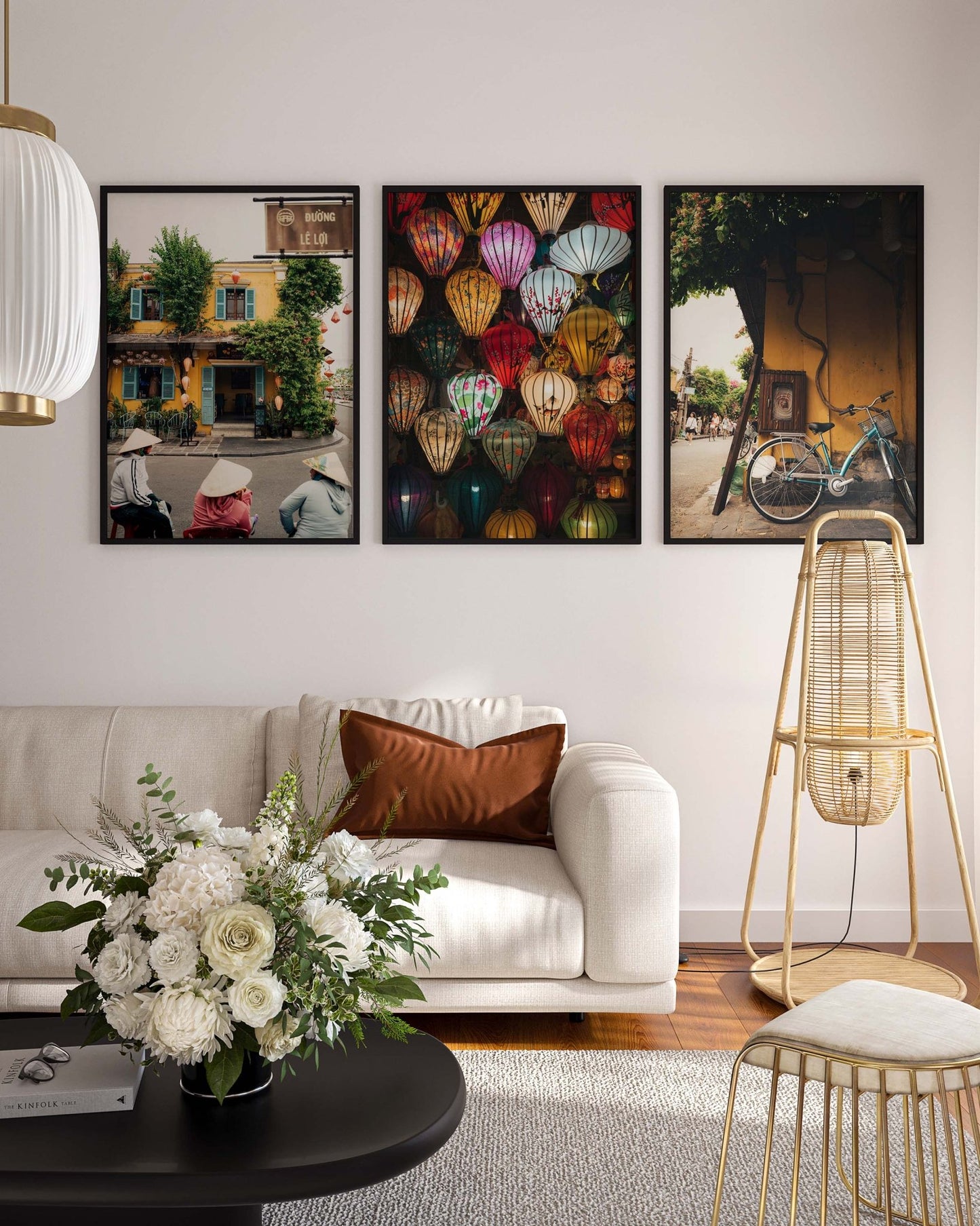 Living room with a white sofa, floral arrangement, and colorful Hoi An Vietnam - Set of 3 framed pictures on the wall.