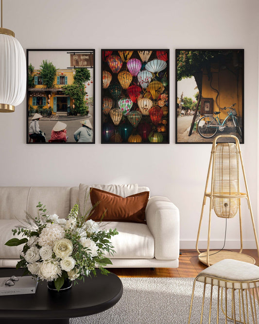 Living room with a white sofa, floral arrangement, and colorful Hoi An Vietnam - Set of 3 framed pictures on the wall.